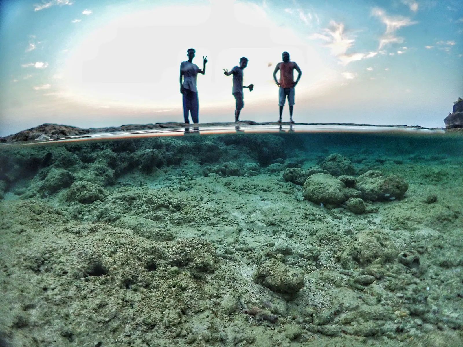 Edited Insta360 underwater — wide over-under of friends on a Havelock shore